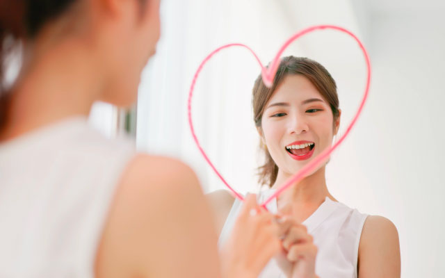 une femme se regarde dans le miroir